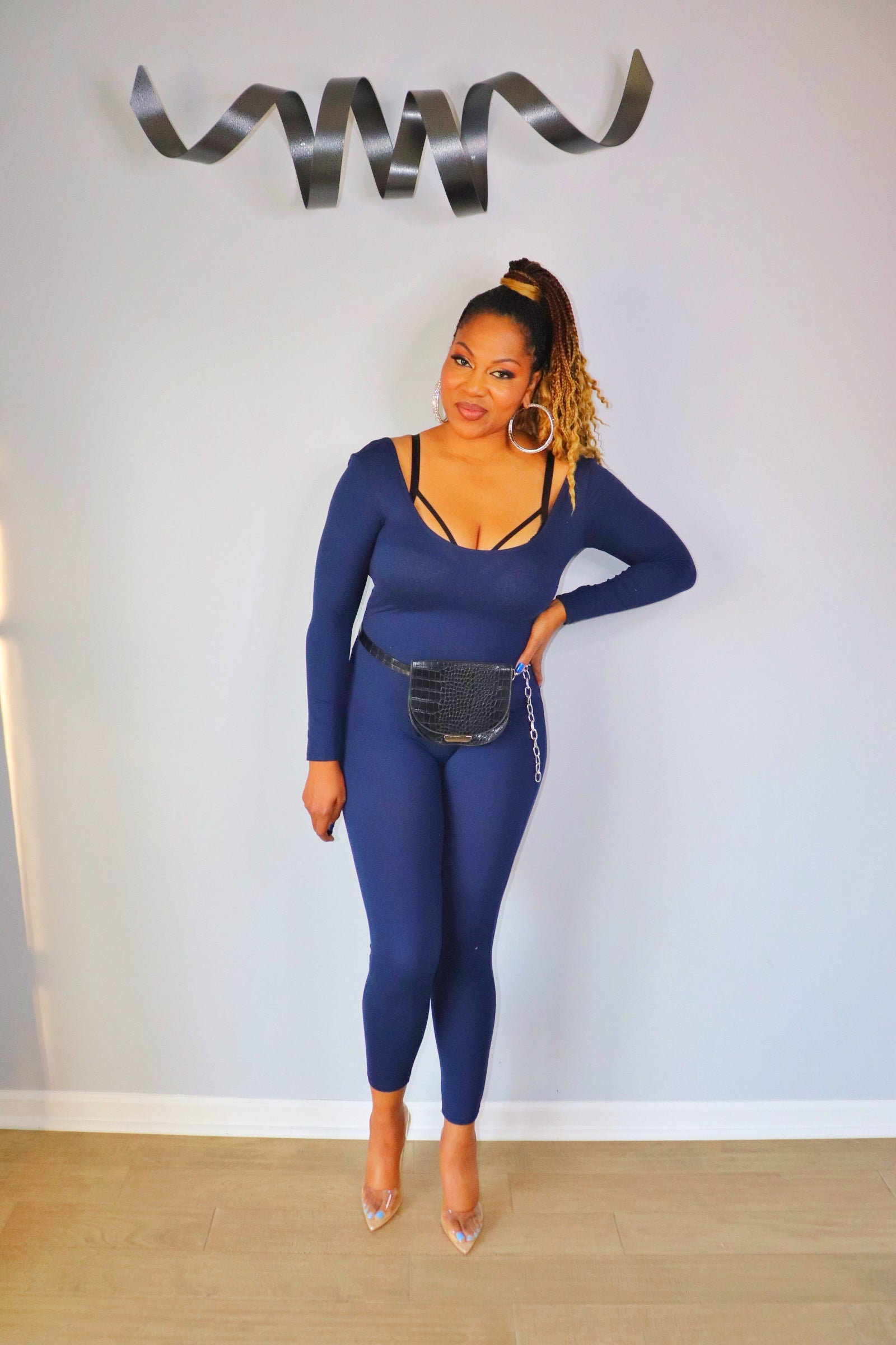 Woman wearing navy scoop neck bodycon jumpsuit from Adrienne Rebecca Boutique