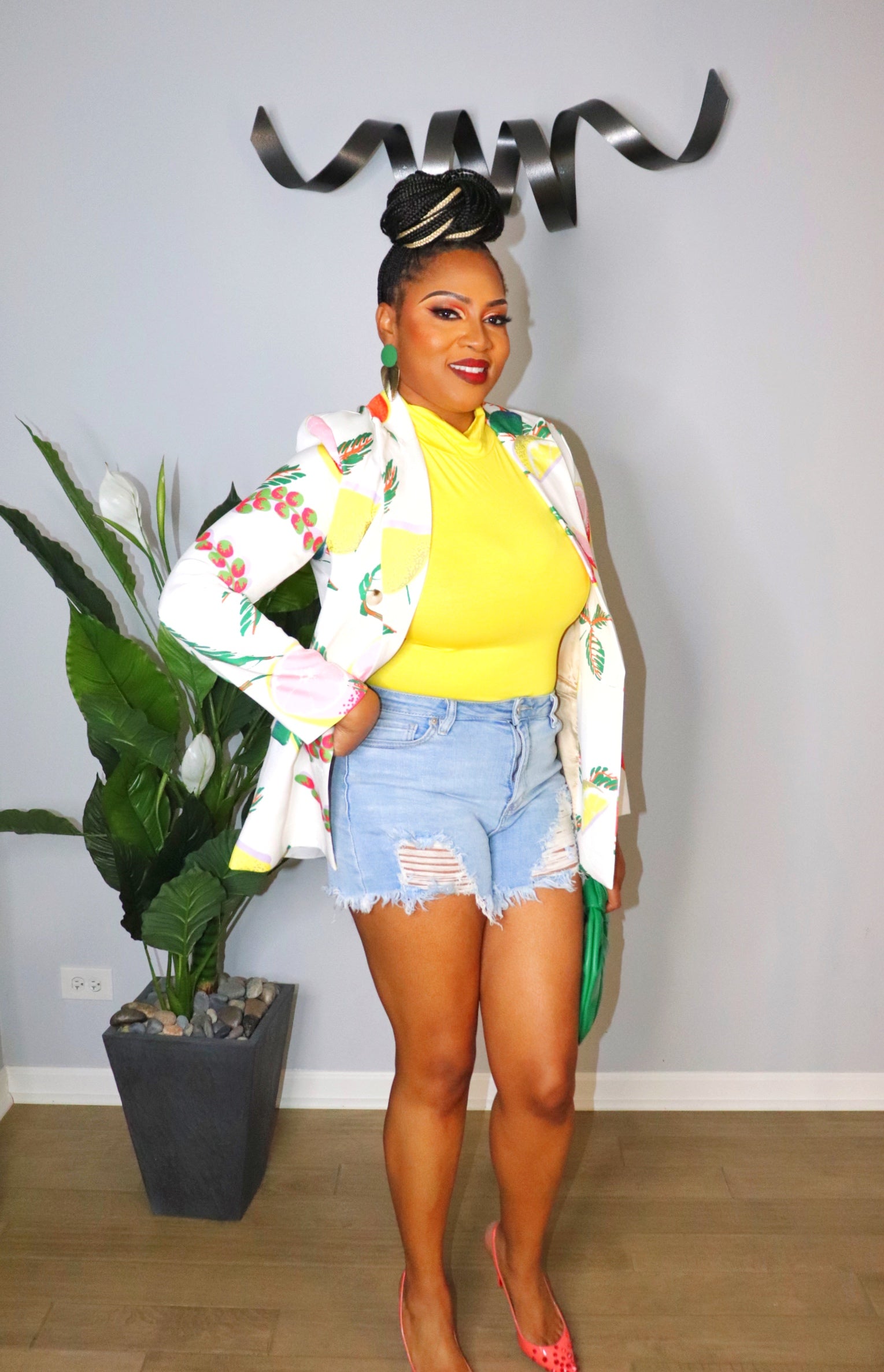 Woman wearing light wash high-waisted denim shorts with raw hem from Adrienne Rebecca Boutique