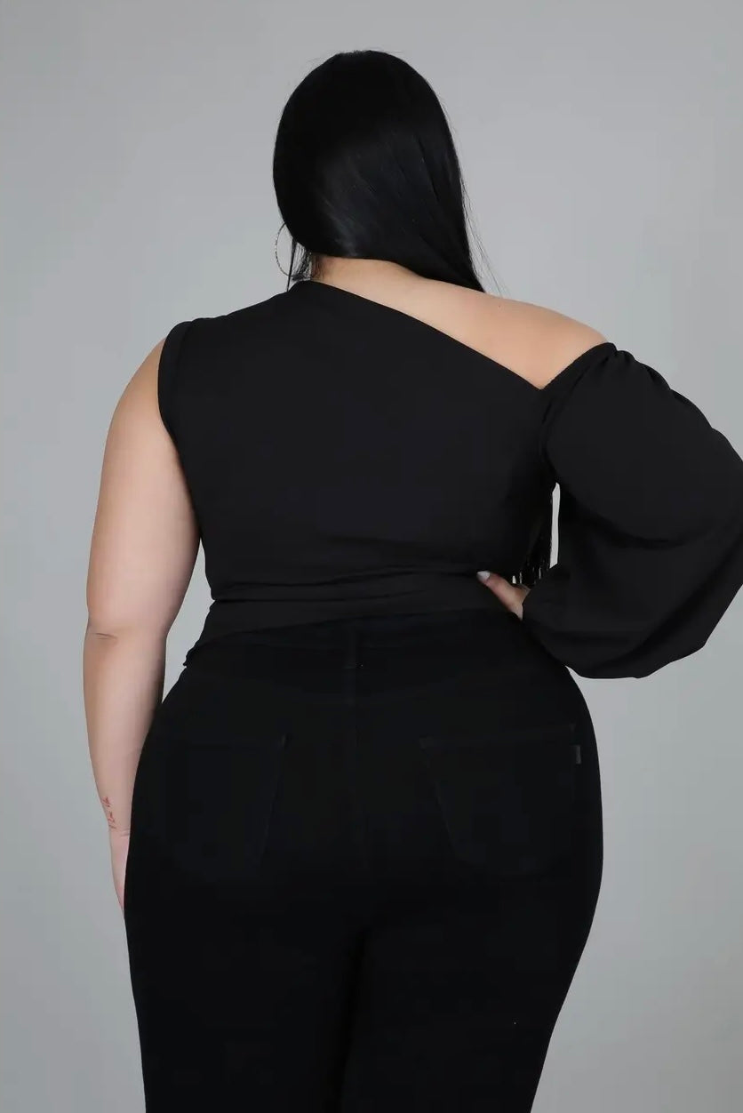 Plus size woman wearing black one-shoulder puff sleeve top from Adrienne Rebecca Boutique styled for evening wear