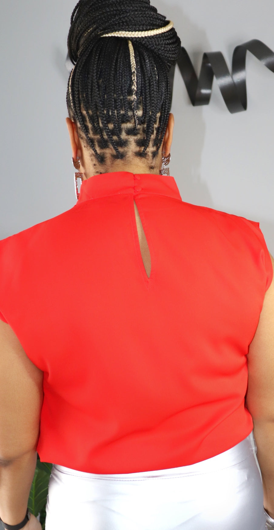 Woman wearing crimson red sleeveless high-low blouse from Adrienne Rebecca Boutique