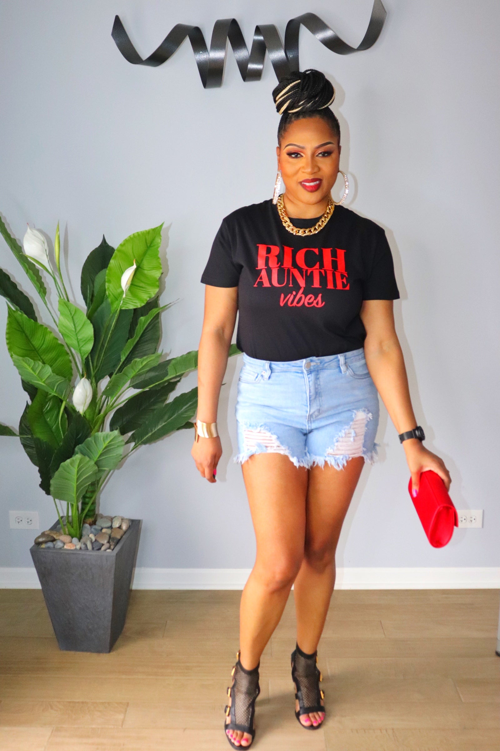 Woman wearing light wash high-waisted denim shorts with raw hem from Adrienne Rebecca Boutique