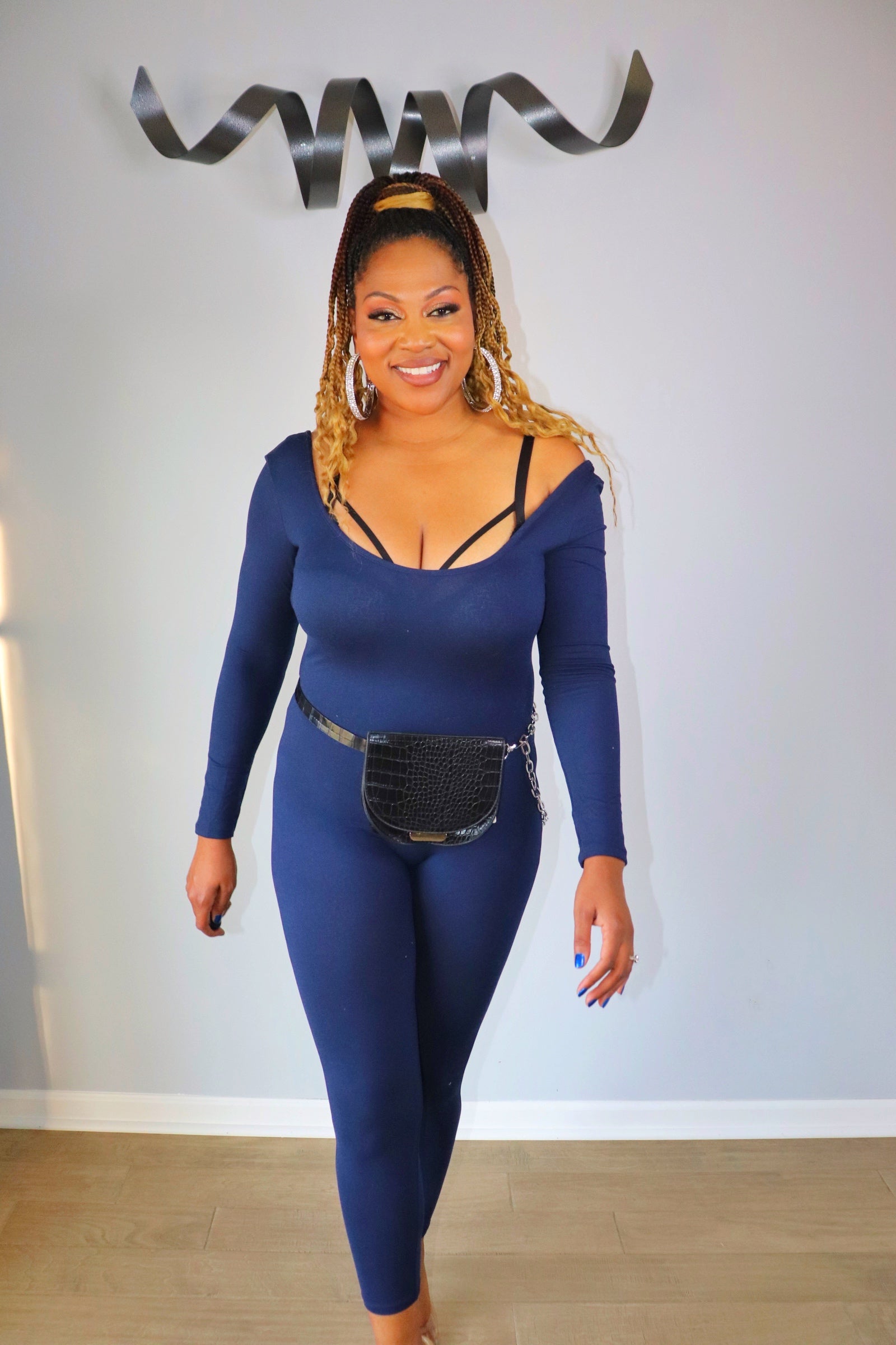 Woman wearing navy scoop neck bodycon jumpsuit from Adrienne Rebecca Boutique